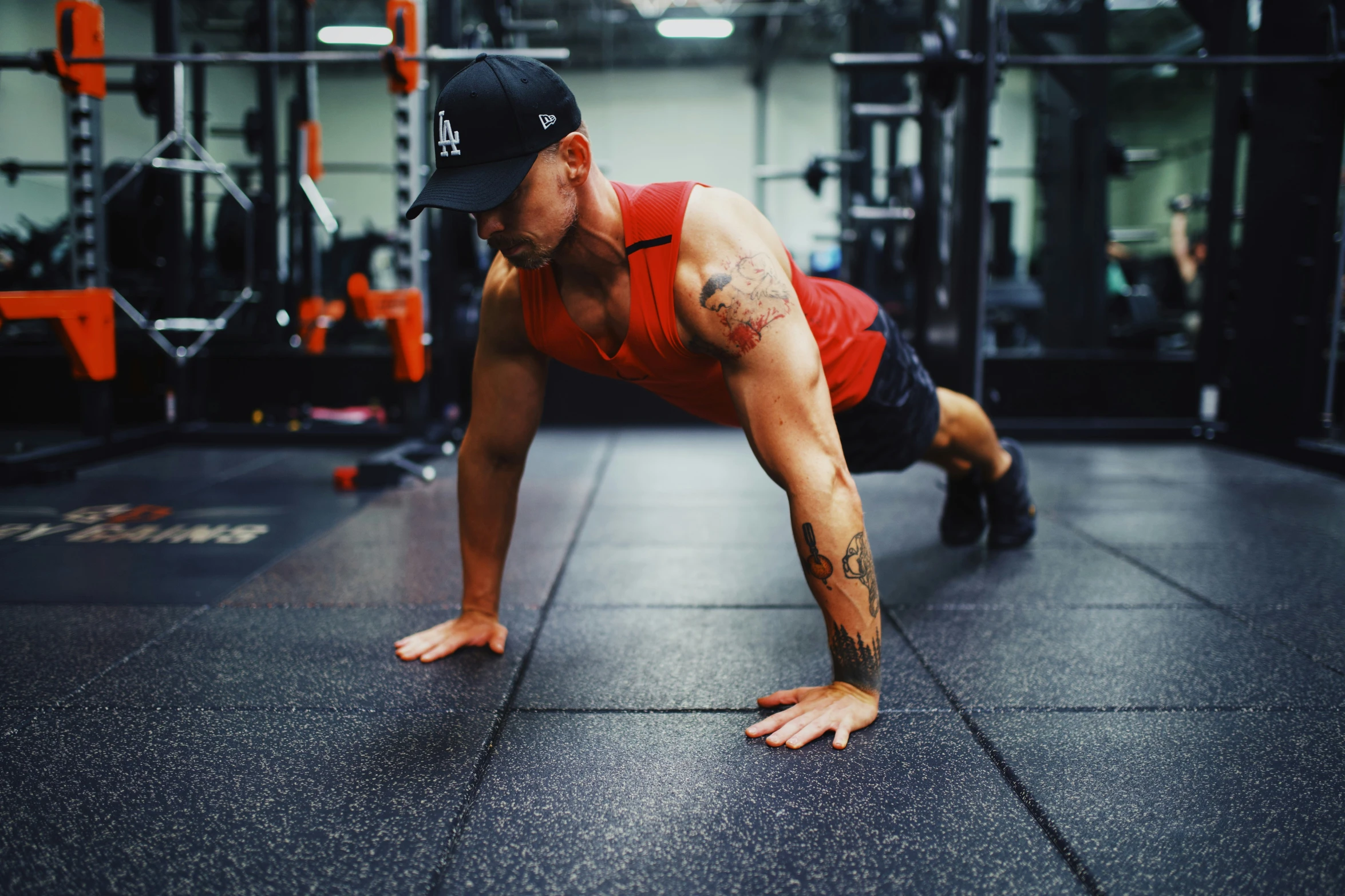 man working out in the gym with his hand on the ground