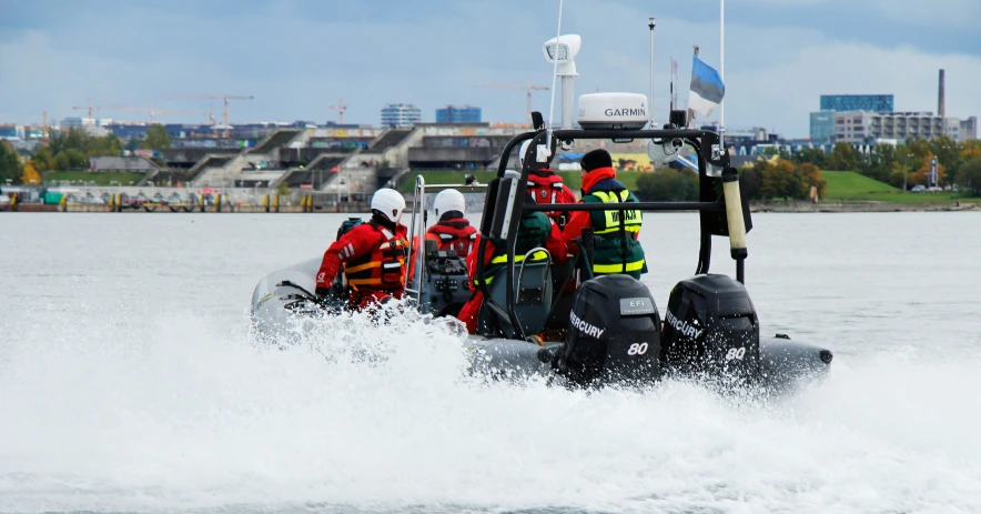 people in life jackets riding on a small boat