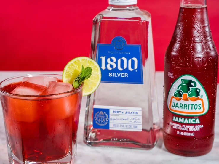 two bottled beverages on the table and one with a lime wedge