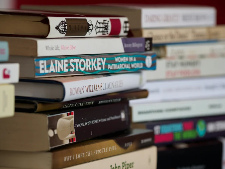 a stack of books sits next to an ipod