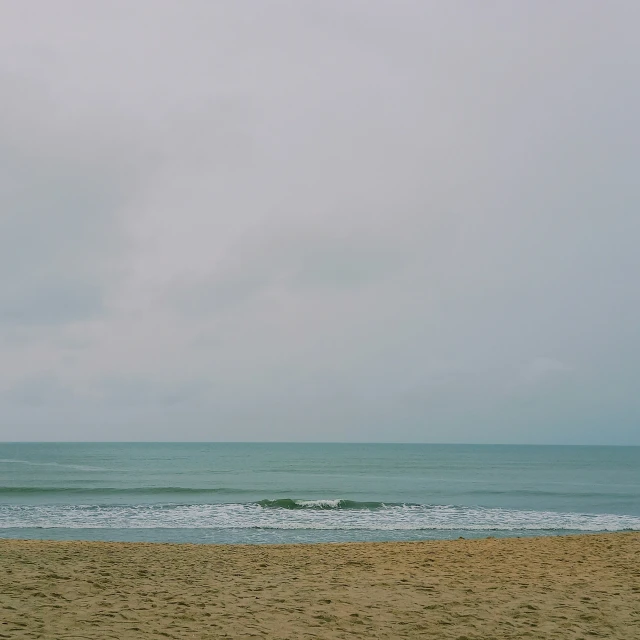 the beach is lined with green water and people are surfing