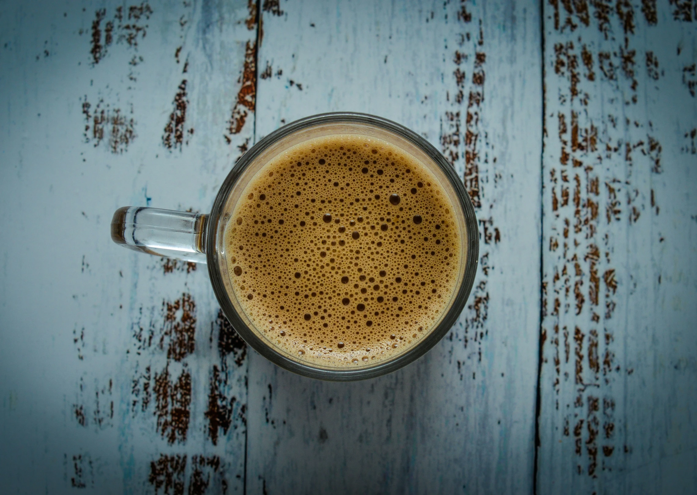 a cup of coffee with brown syrup on top