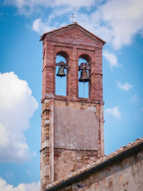 the top of a church bell tower has two bells