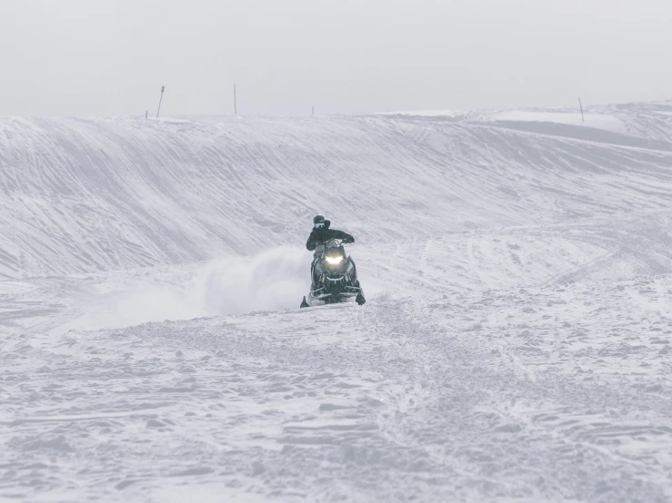 a man riding a snowboard down the side of a snow covered slope