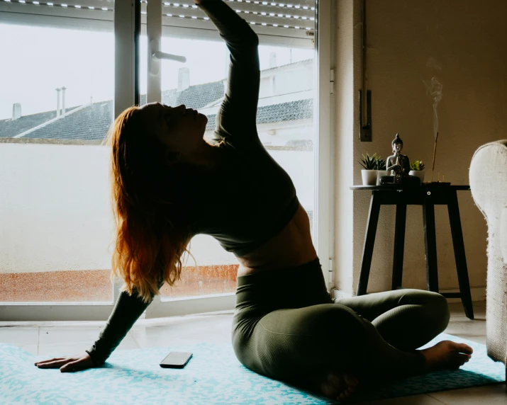 a woman stretching her leg out and doing yoga