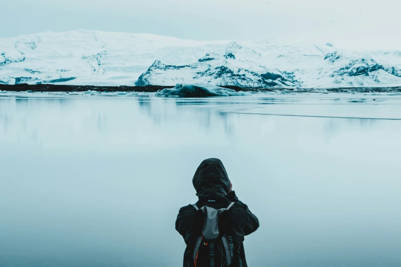 a man standing on the side of a lake