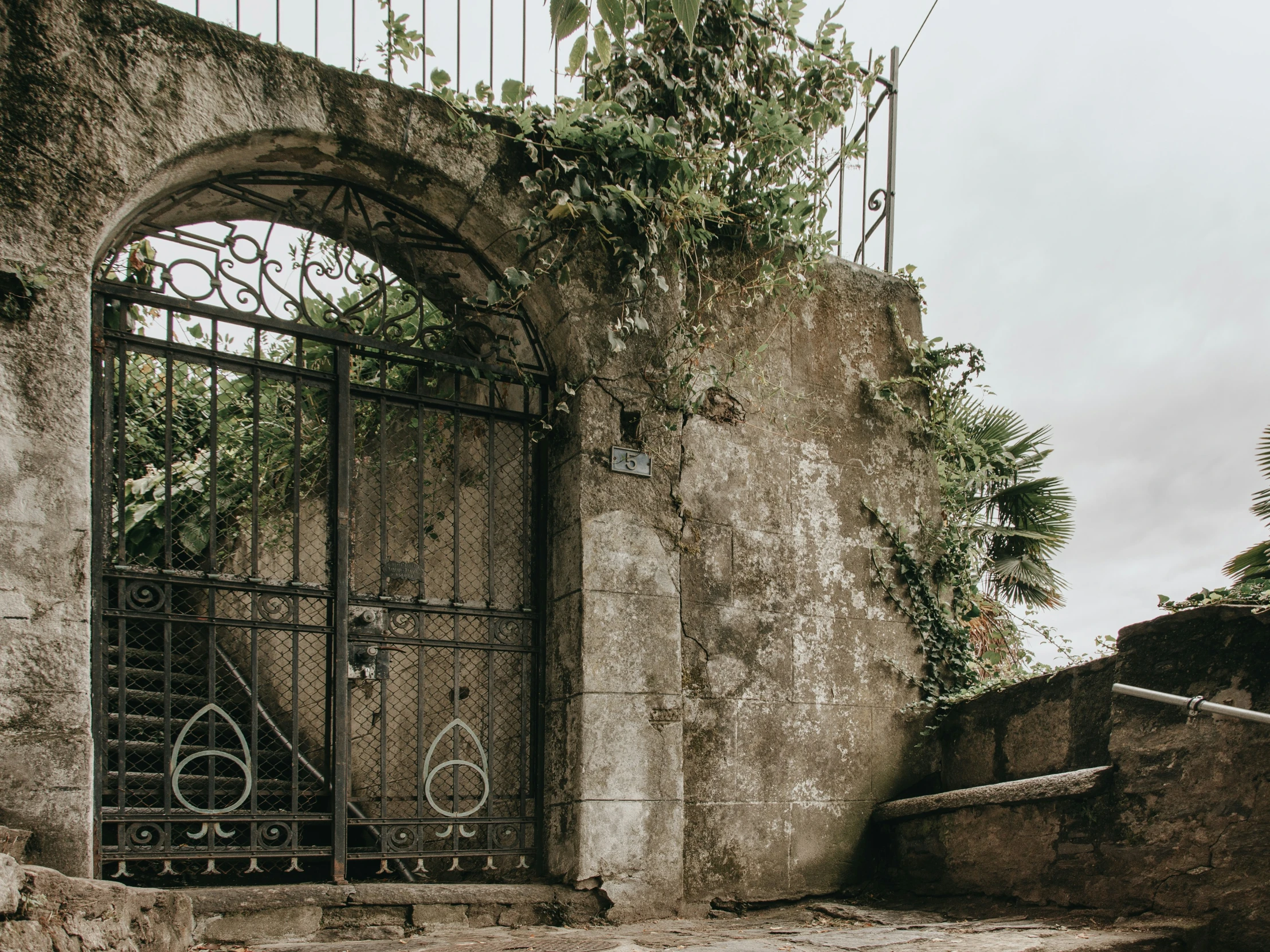 a very old door and the bike locked by the iron bars