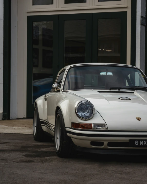 a white vintage porsche parked on the street