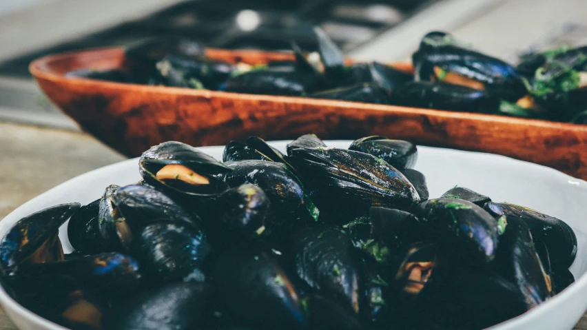 some black mussels in a bowl on a table