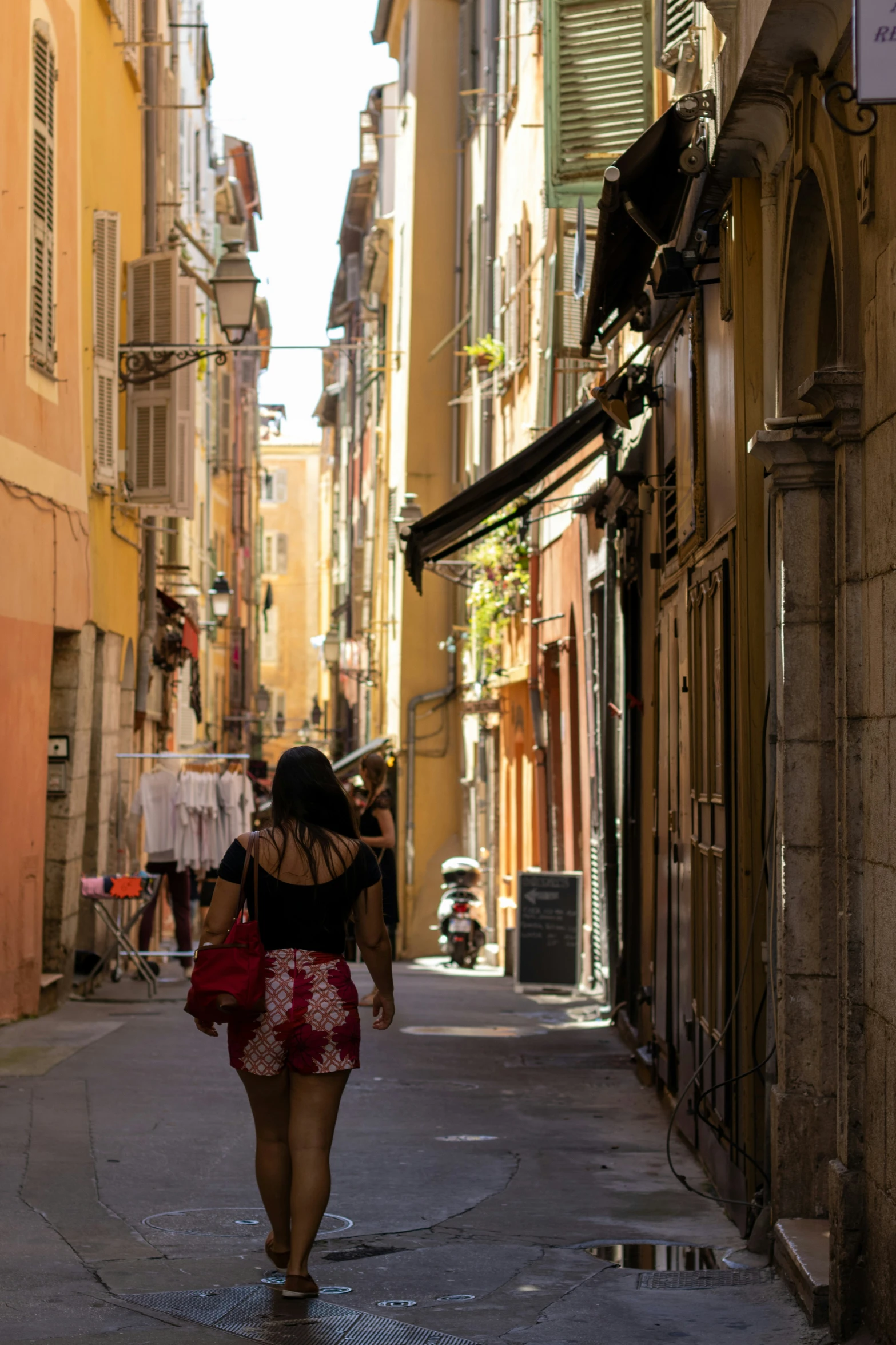 a woman walking on a street with old buildings