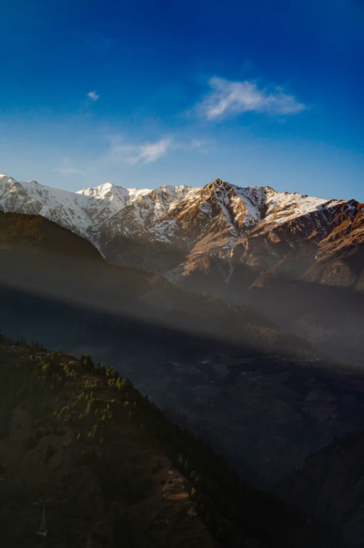 a clear blue sky above some snowy mountains