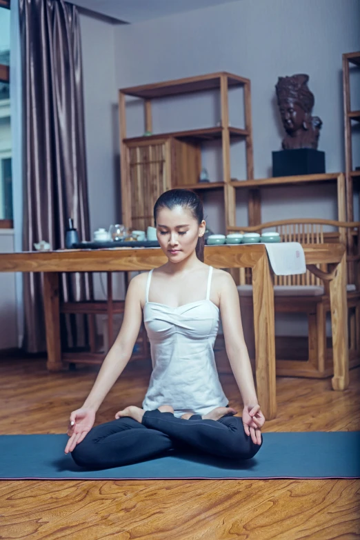 a woman doing yoga poses in front of a wooden table