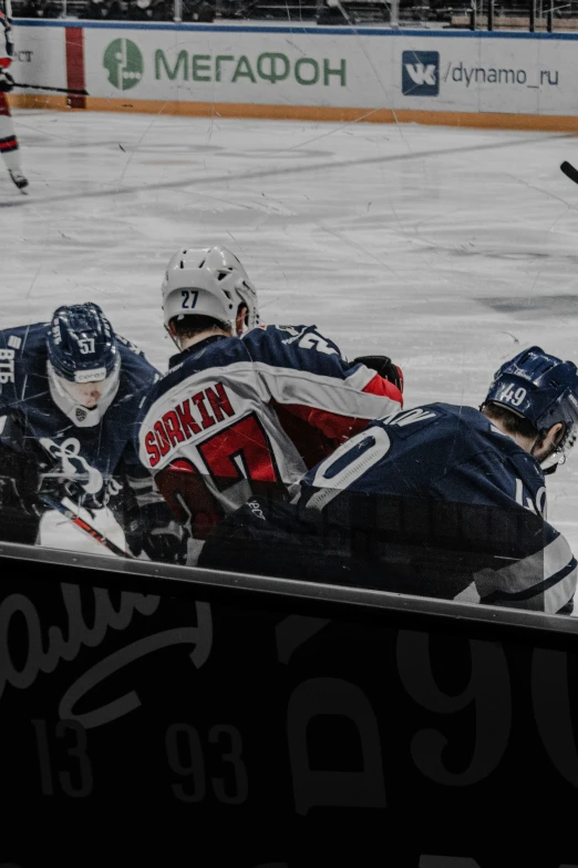 a hockey game with players in blue uniforms and helmet and hockey sticks