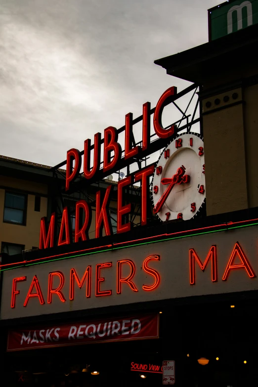 a farmers market with a large neon sign