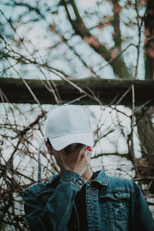 the young man wearing a hat looks up at the nches