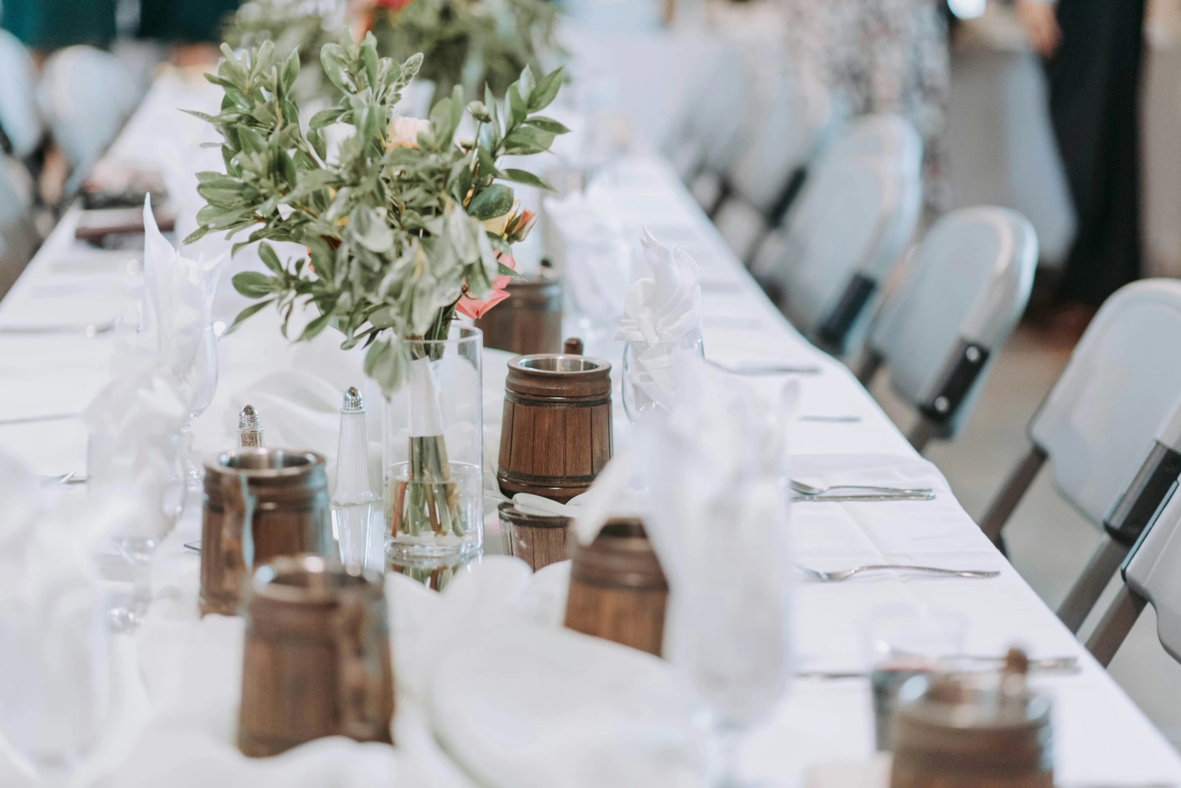 a table is set with flower arrangements and place settings