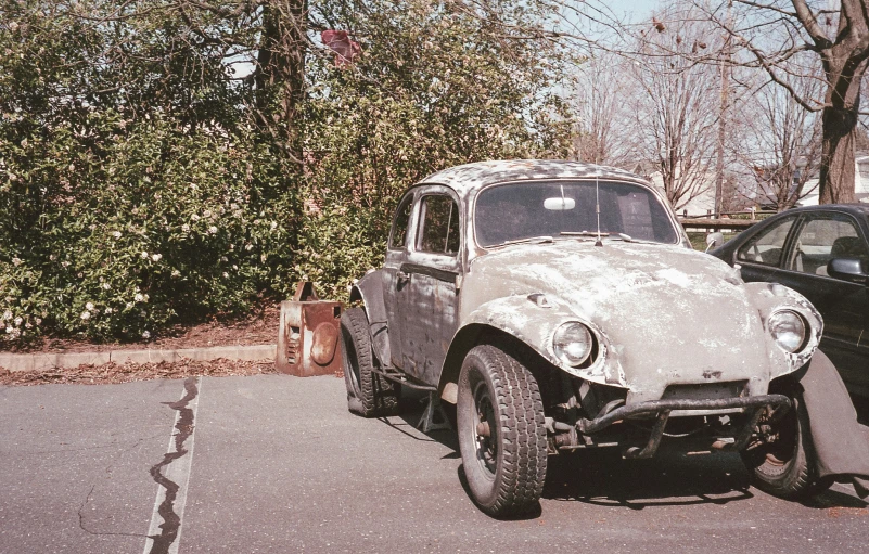 an old - fashioned, dirty automobile is parked in the street