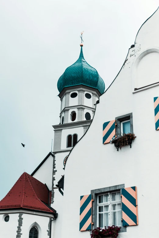 white and blue building with green roof and decorative windows