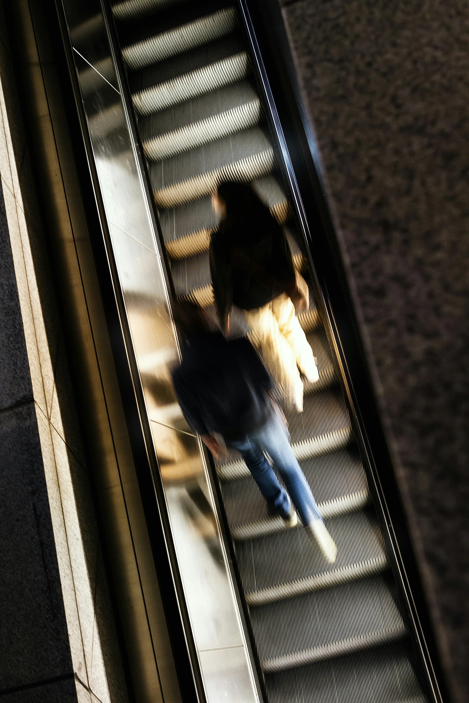 a woman walking on an escalator holding an umbrella