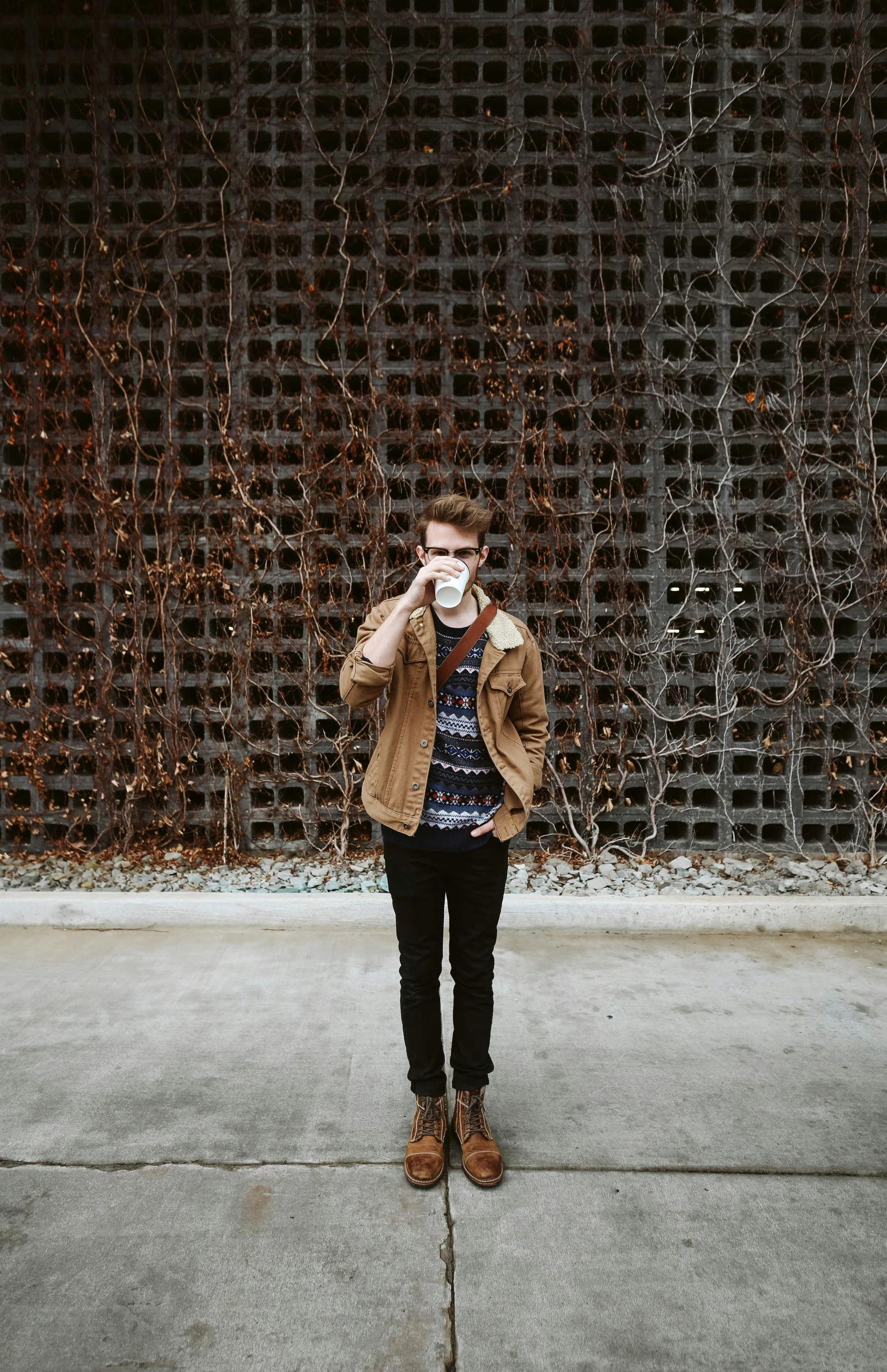 a man that is standing in the cement with a sweater