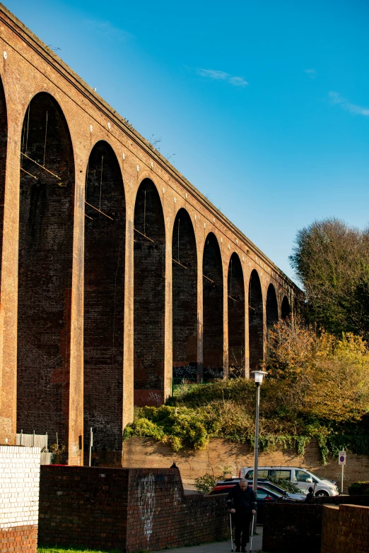 a tall brick bridge sitting on top of a lush green hillside