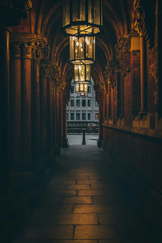 an empty hallway between two buildings with street lights