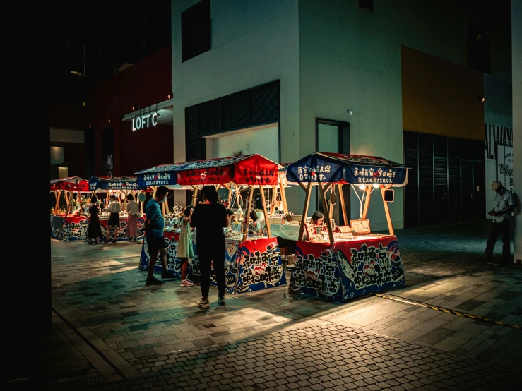 people browsing the booths at night on the streets