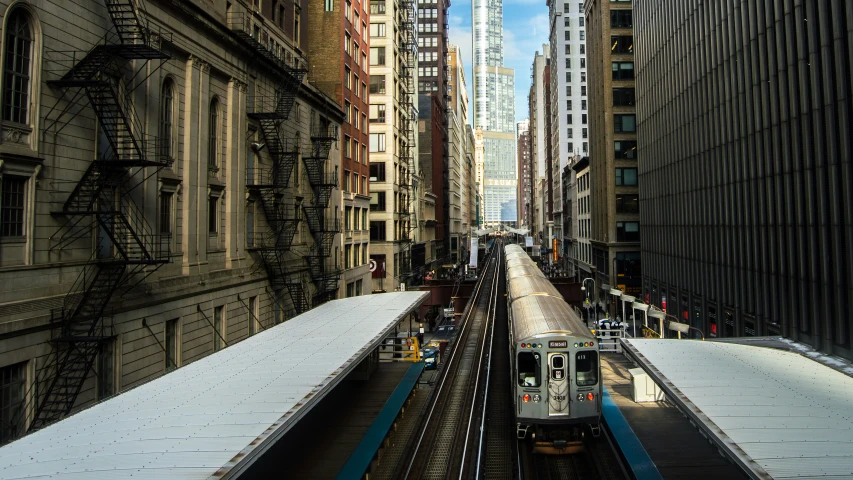 a train traveling through a very tall city