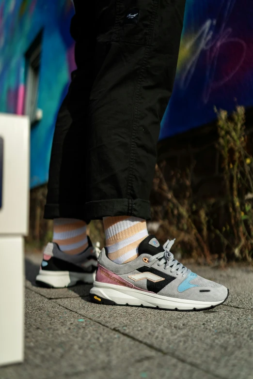 the legs and shoes of someone in front of a painted wall