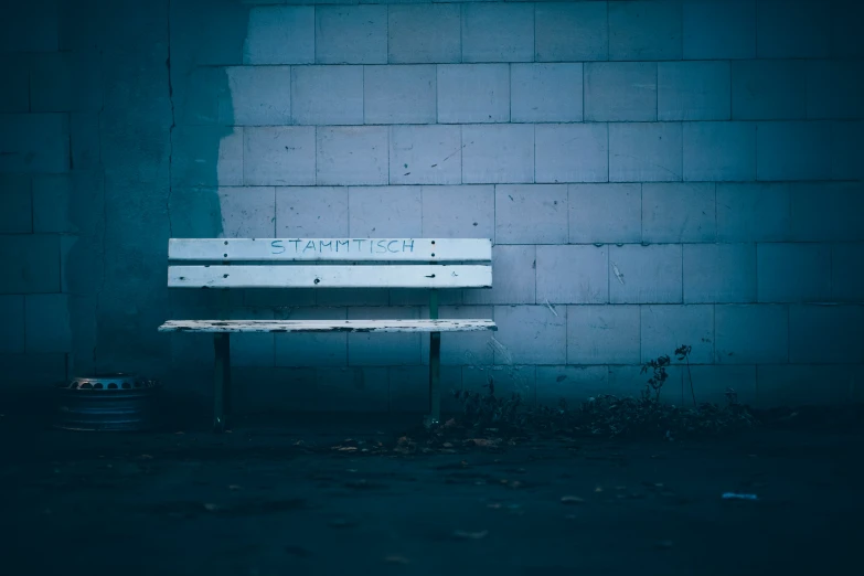 a white bench is sitting against the wall