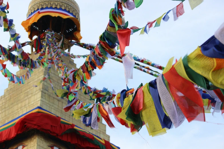 many colorful streamers are hanging from a tall tower