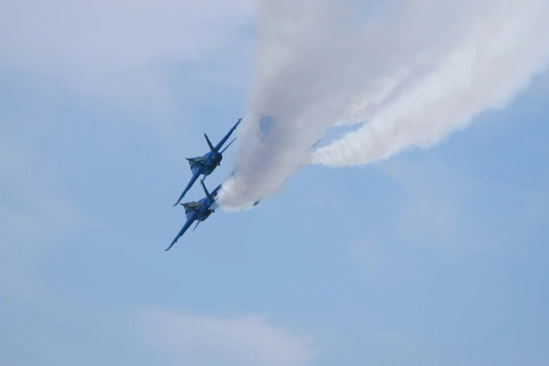 two airplanes flying close to each other with white smoke coming from the planes