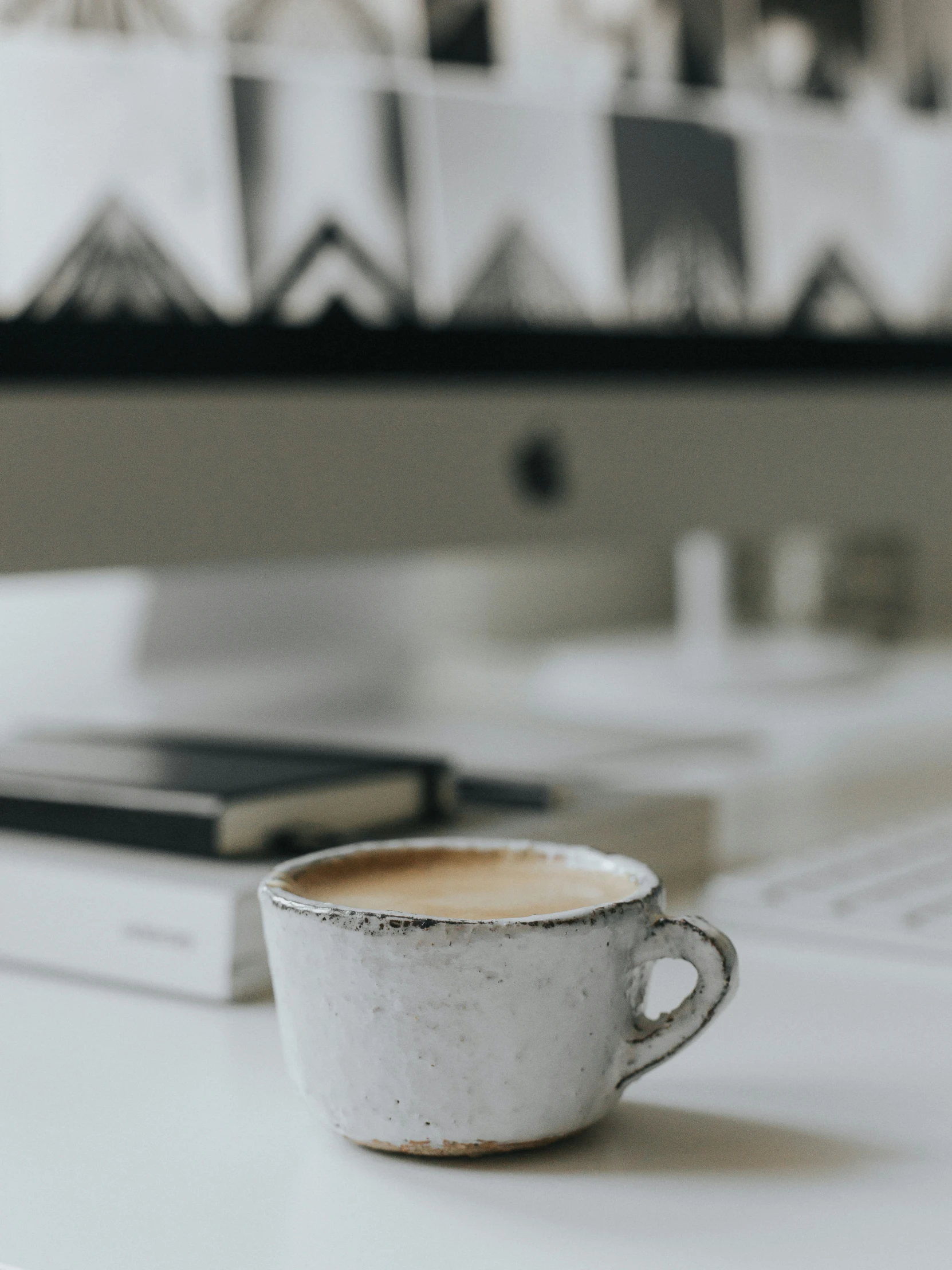 an old cup with a brown liquid sits on a desk