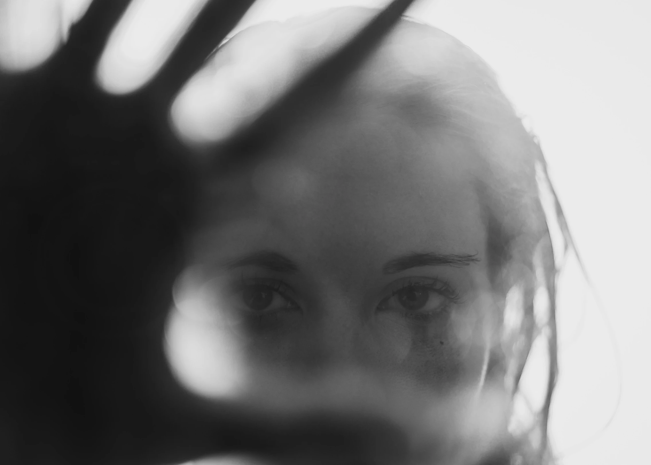 woman in the foreground looking in to her left and a mirror behind her