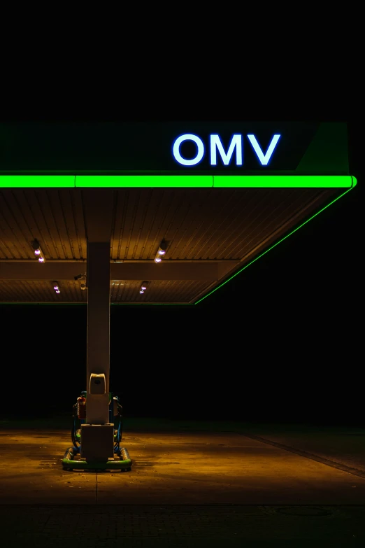 a lighted sign points in the direction of a gas station