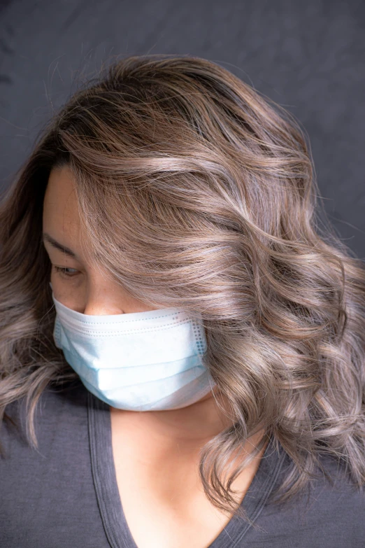 a woman wearing a surgical mask with fabric over her mouth