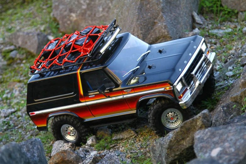 a car with a basket on the roof parked by rocks