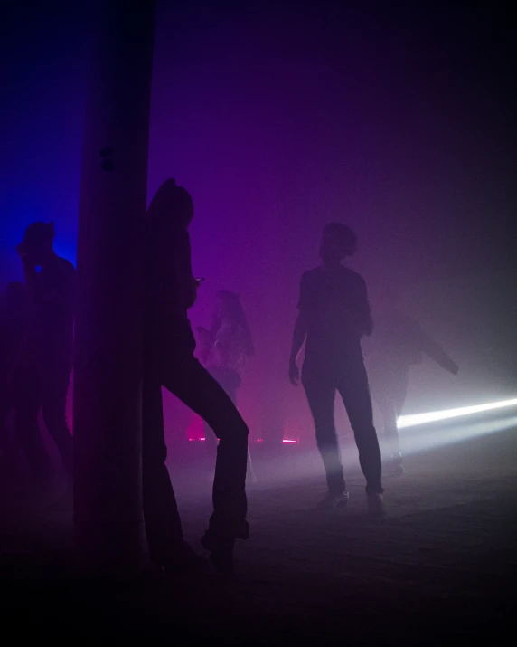 people are standing on the road at night time