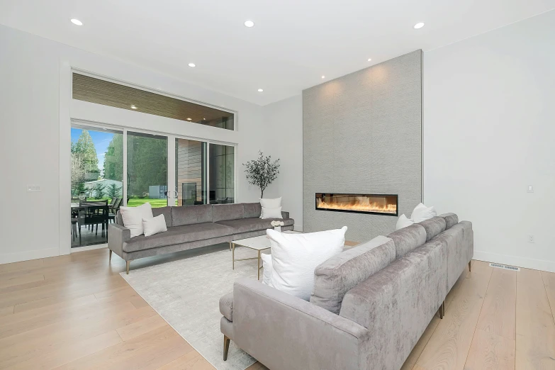 an open plan living room with couches and an open fireplace