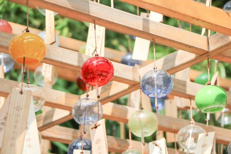 a bunch of colored balls hanging from a beam