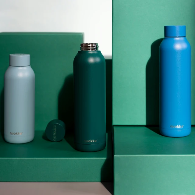 different blue and green bottles on some shelves