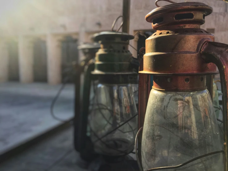 two old fashioned oil lamps sitting outside a building