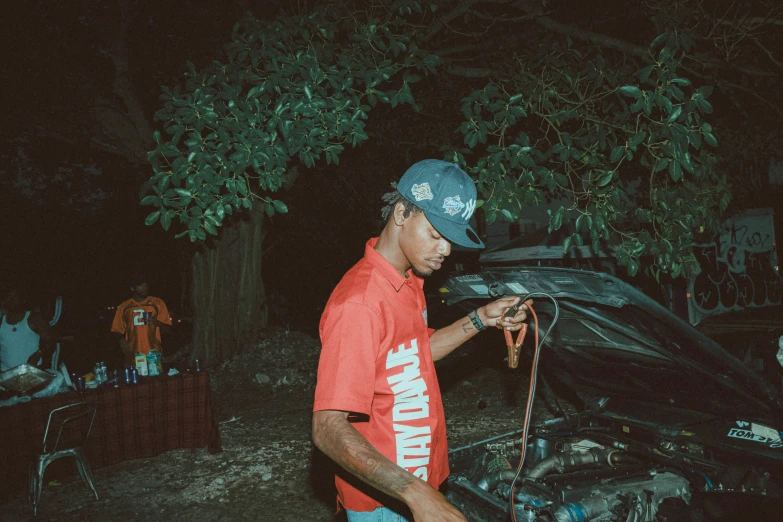 a man standing over an engine in the dirt