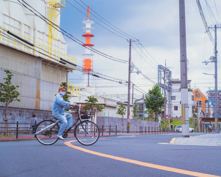 a man riding on the back of a bicycle down a street