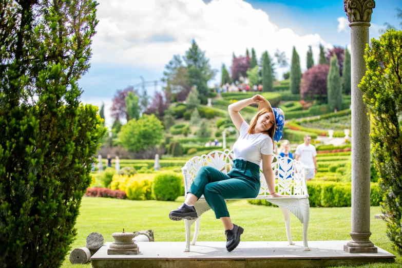 a woman sitting on top of a white bench