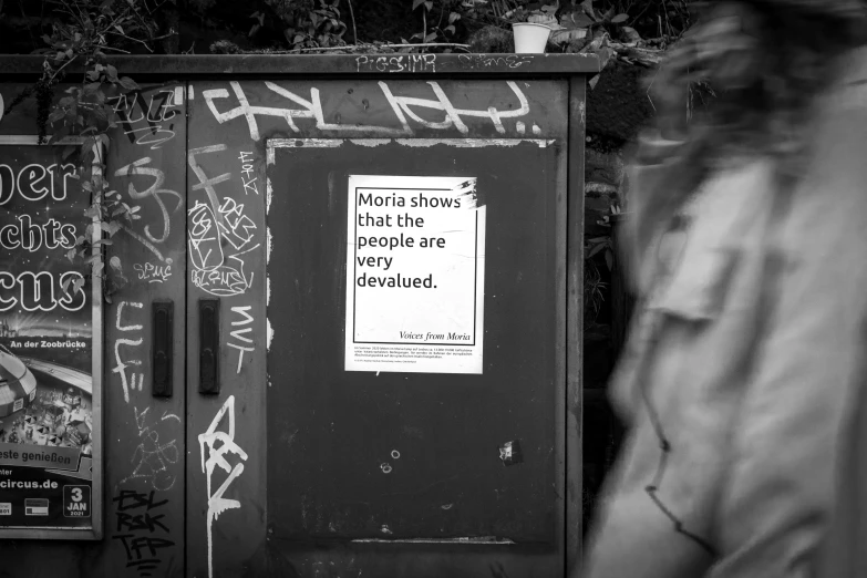 someone standing next to a small refrigerator with graffiti on it