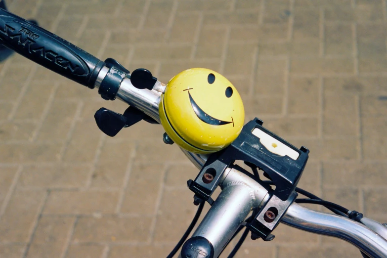 a bicycle handlebar with a smiley face shaped ball on it