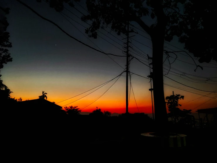 a dark picture with a cross in the sunset