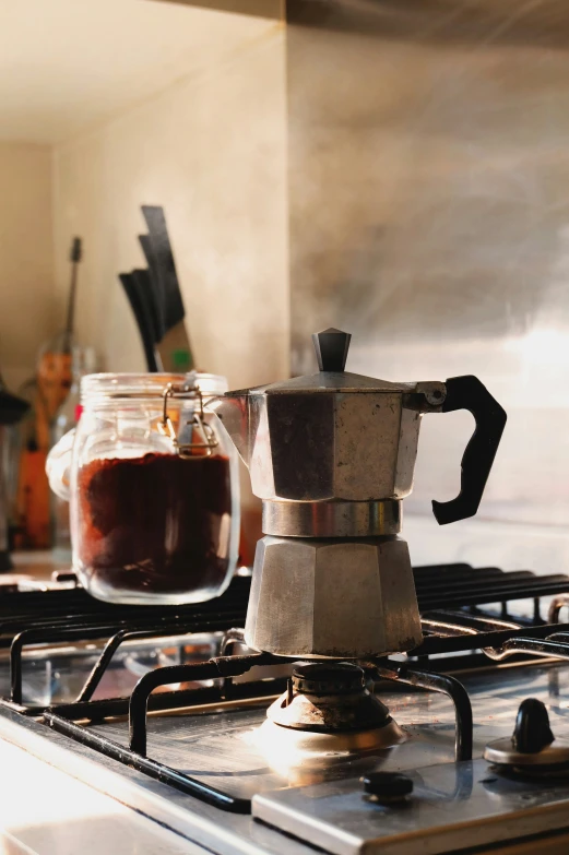 an espresso coffee maker sitting on top of a stove