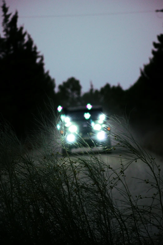 a truck with three lights drives along a road at night